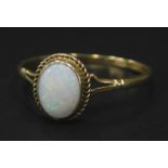 A 9ct gold dress ring, set with opal, with a beaded surround, and pierced shoulders, 1.6g all in.