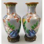 A pair of Japanese cloisonné vases, each decorated with flowers, birds etc., 23cm high, on