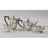 A George V silver four piece tea set, with tapering faceted sides, composition handle and knop to