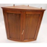 A 19thC style mahogany corner cupboard, of small proportion, the panelled doors hinging to reveal