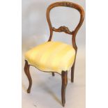 A Victorian mahogany balloon back chair, with a scroll carved rail back, a striped padded seat, on