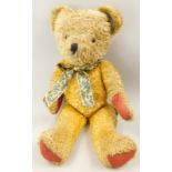 A gold cotton plush teddy bear, with red leatherette triangular pads, 56cm long