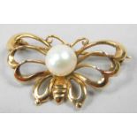 A butterfly brooch, set to the centre with a cultured pearl, yellow metal, marked K14, 2.2g all in.