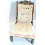 A Victorian mahogany nursing chair, with a carved show frame, button back, padded seat, on turned