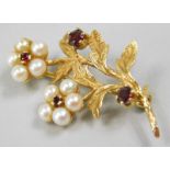 A 9ct gold floral brooch, set with pearls and garnets, formed in a floral spray, 4.6g all in.