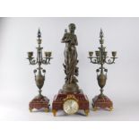 After Eutrope Bouret. A French bronze and marble clock garniture, the clock mounted with a figure of