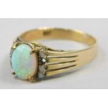 A dress ring, set with oval opal, flanked by four tiny diamonds to each side (1 missing), with