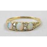 An 18ct gold opal and diamond dress ring, set with three opals and four tiny diamonds, 2.6g all in.