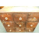 A bank of nine Victorian pine shop fittings or drawers, each with glass handles, (AF), 62cm wide