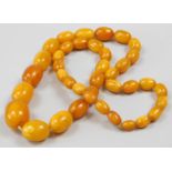 Withdrawn prior to sale. A butterscotch amber necklace, with graduated beads, on string, largest