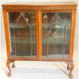 A mahogany display cabinet, with two glazed doors, a blind fret frieze on cabriole legs, with ball