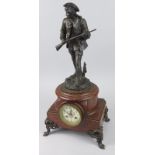 A French spelter and rouge marble mantel clock, the figural surmount titled 'Le Chasseur Parbouret',