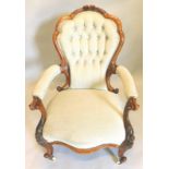 A Victorian walnut showframe open armchair, with padded button back, padded arm rests and seat,