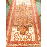 A Persian rug, with a design of geometric medallions, birds etc., on a blue ground, mainly in red,