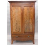 An early 19thC mahogany bow front armoire wardrobe, with fixed dentil cornice raised above two