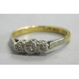 An 18ct gold and platinum dress ring, set with three illusion set tiny diamonds, with engraved