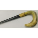 An early 20thC ebonised walking stick, with horn handle and yellow metal collar stamped 18ct,