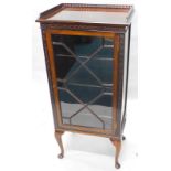 A early 20thC mahogany music cabinet, the top with a pierced gallery above a single door flanked