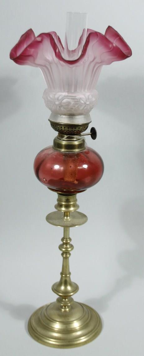 A late 19thC cranberry and brass oil lamp, of small proportion, with clear funnel, frosted clear and