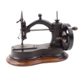 A late 19th/early 20thC cast iron hour glass shaped sewing machine, with turned wooden handle,