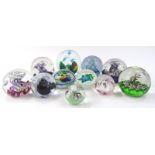 Various 20thC glass paperweights to include a swirl example set with blue and green flower, marked