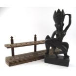 A carved ebonised Indian god dancing, in flowing robes, on a block base with a bead outline, 43cm