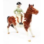 A Beswick equestrian group, girl on brown and white pony, printed marks beneath, 15cm high. (AF)