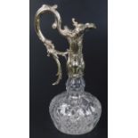 A 19thC crystal glass and silver plated claret jug, with leafy 'S' scroll handle, articulated lid