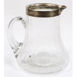 A George V silver and glass lemonade jug, with plain handle, ribbed body and plain neck,