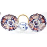 A matched pair of Japanese Imari plates, each of floral outline and decorated with central vases