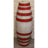 An early 20thC painted coopered barrel, of shaped outline, with eight sectional banding in red and