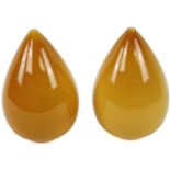 A pair of amber coloured glass domes, each of acorn outline, plainly decorated on circular feet,