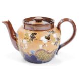 An early 20thC Royal Doulton stoneware teapot, the circular textured body raised with flowerheads