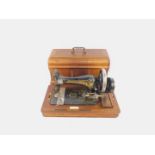 A Frister & Rossmann sewing machine, No 115O5 993, cased with plaque named Frisby Dyke & Company,