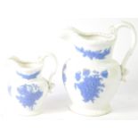 A pair of early 19thC porcelain graduated jugs, sprig moulded with turquoise clusters of flowers,