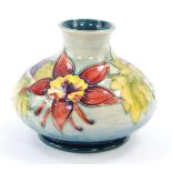 A Moorcroft pottery vase decorated in the Columbine pattern, of squat baluster form, painted
