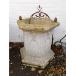 A faux marble hexagonal well, plastic with a cast iron arbour, moulded decoration raised on a