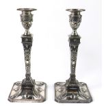 A pair of Edwardian Neo classical style silver plated candle sticks, cast with classical urns,