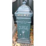 A green painted metal Continental style post box, 103cm high.