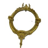 A 19thC gilt gesso wall mirror, decorated with bell flowers, etc, the oval plate surrounded by three