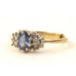 A 9ct gold dress ring, set with raised floral cluster, with oval cut, blue stone, and tiny claw