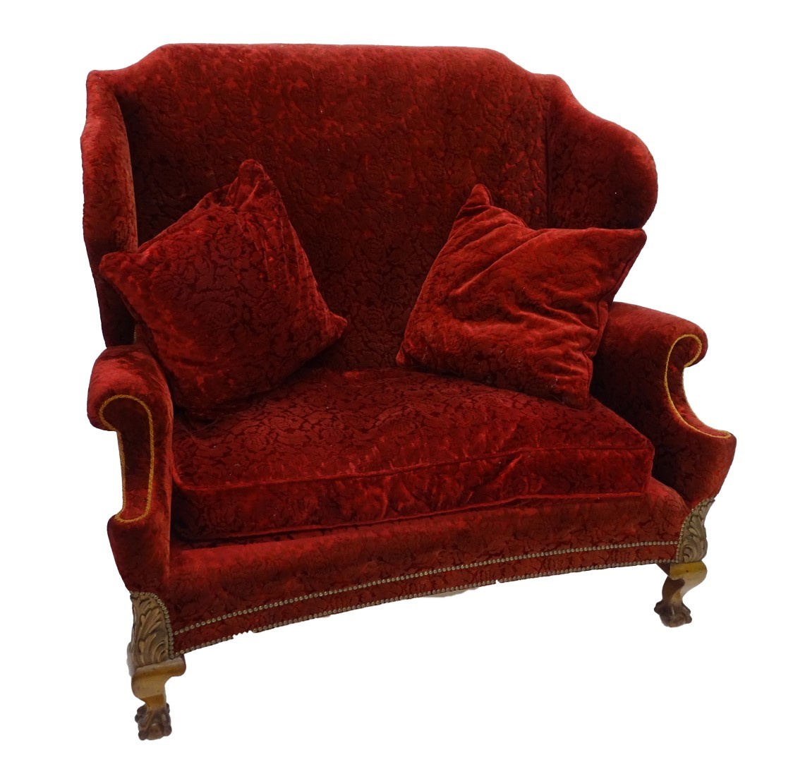 A mahogany wingback sofa in 18thC style, upholstered in red textured floral velvet, with gold piping