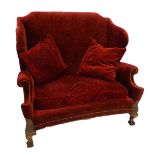 A mahogany wingback sofa in 18thC style, upholstered in red textured floral velvet, with gold piping