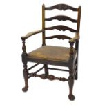 A 19thC oak ladder back armchair, with a drop in seat on cabriole legs with pad feet.