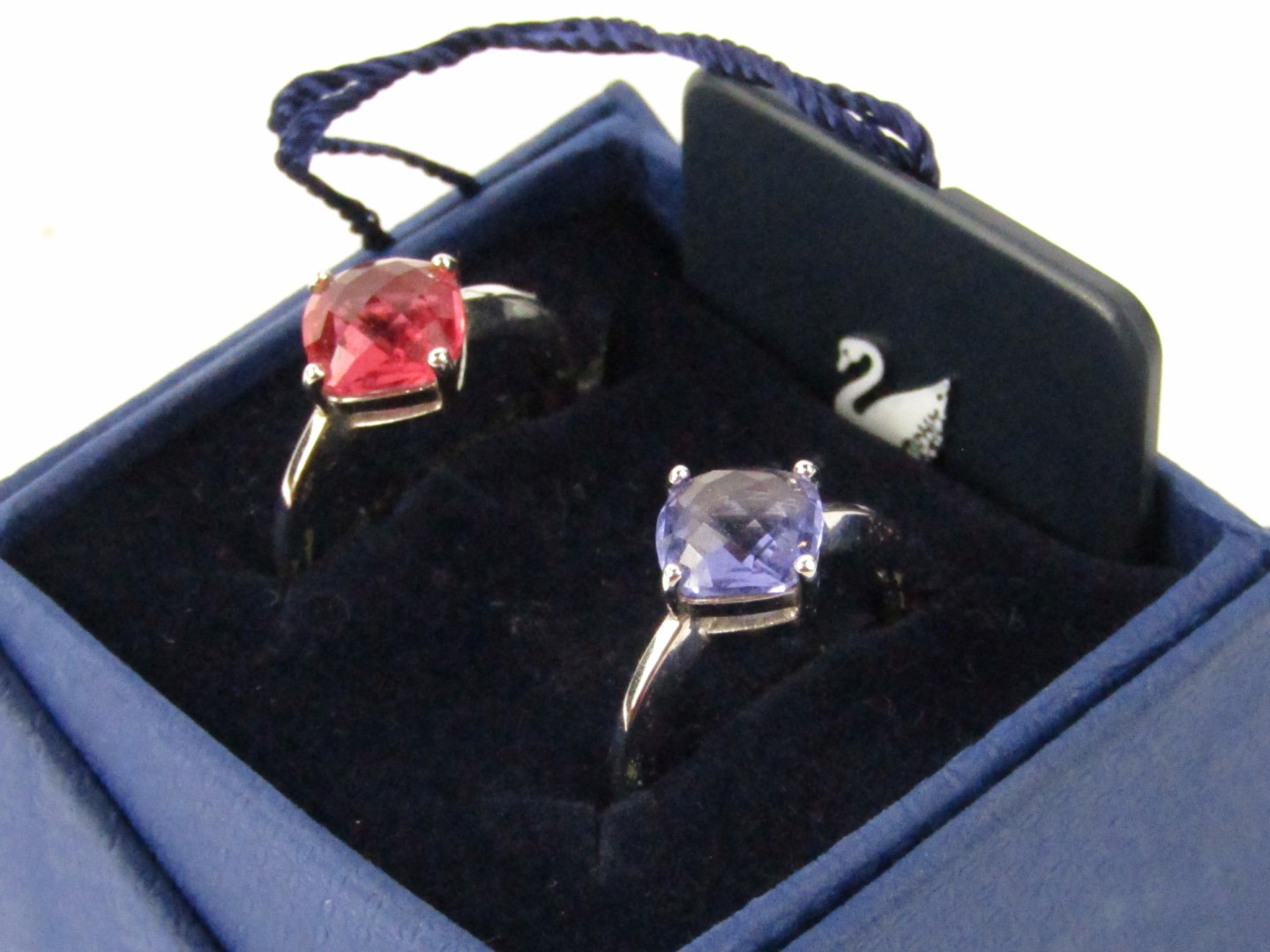 Two Swarovski rings, one with a red coloured crystal and another purple.