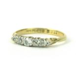 An 18ct gold five stone diamond ring, set with five tiny diamonds, each in claw setting, on thin