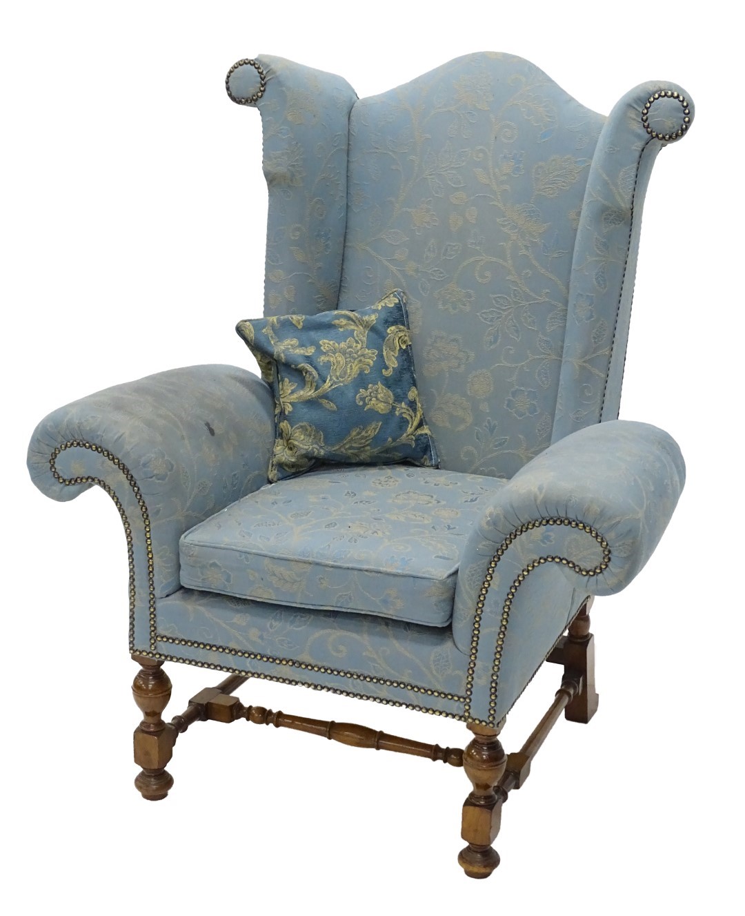 An unusual walnut wingback armchair, upholstered in pale blue and gold patterned fabric with studded