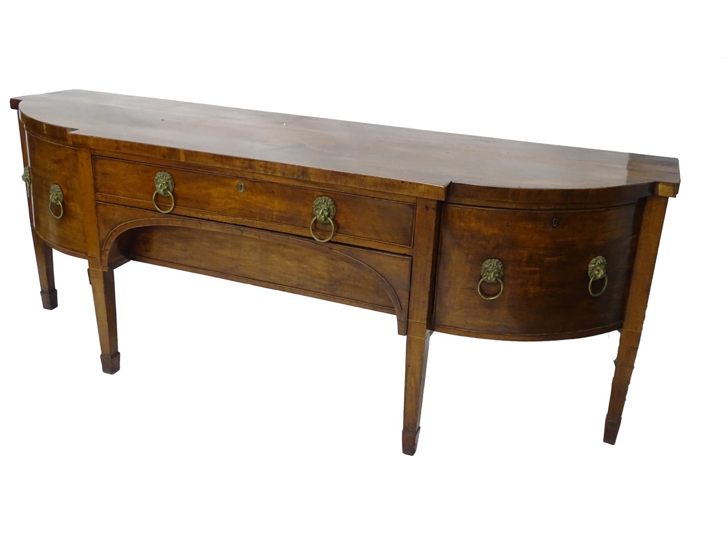 An early 19thC mahogany breakfront sideboard, with brass lion mask handles on square tapering