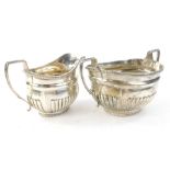 A George V silver two handled sugar bowl, with hall ribbed body and matching milk jug, London