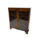 A mahogany bookcase, the top with a moulded cornice above two astragal glazed doors including